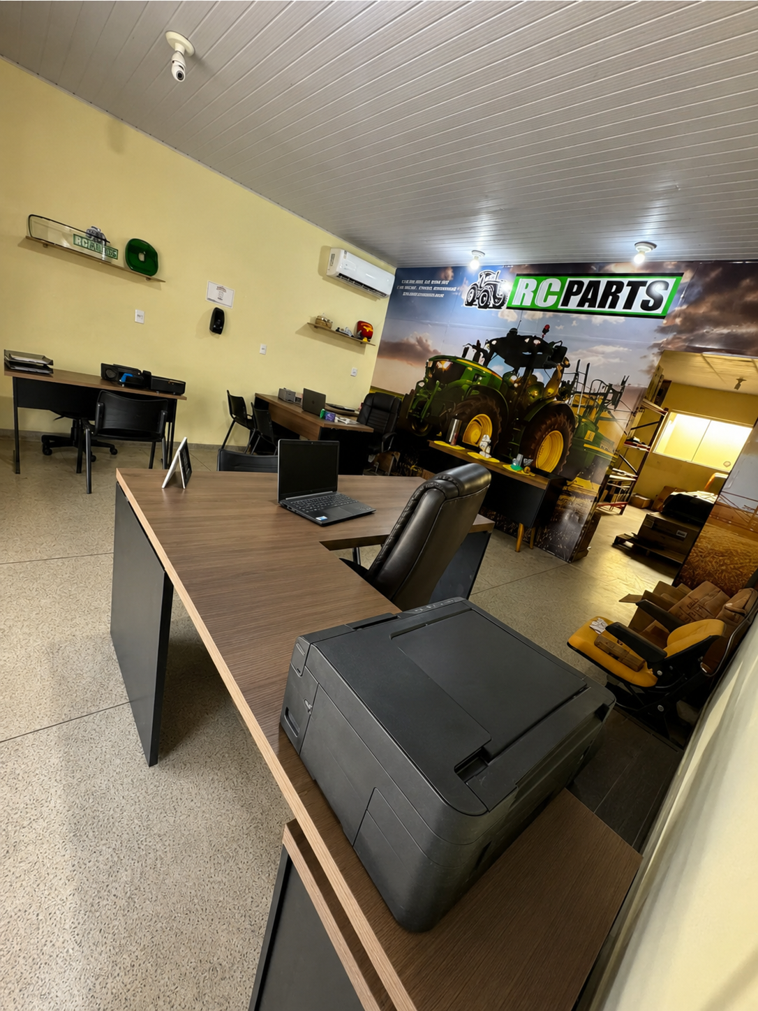 Escritório da RC Parts com identidade visual da marca e mural John Deere